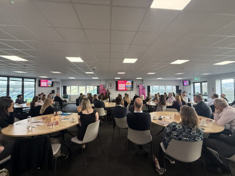 South West commercial property market update event with attendees seated at round tables listening to a presentation in a modern conference room