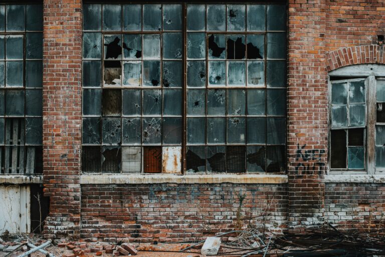 Damaged windows and brickwork on an old commercial building.