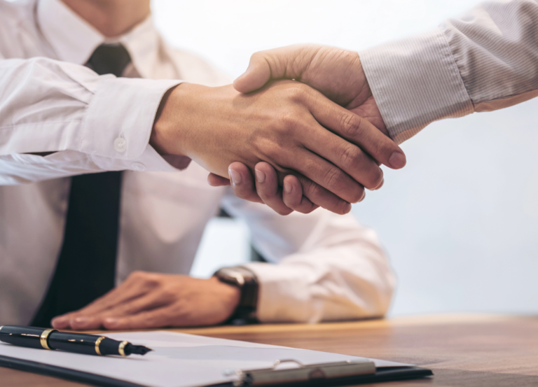 Two people shaking hands after agreeing a formal building contract