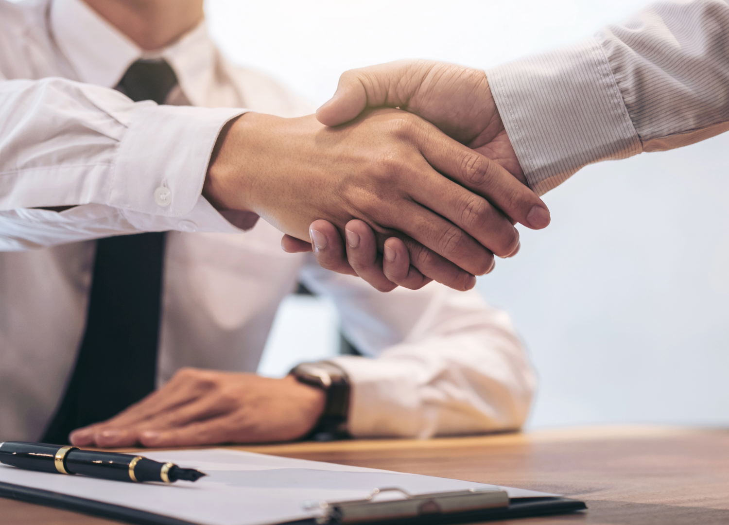 Two people shaking hands after agreeing a formal building contract